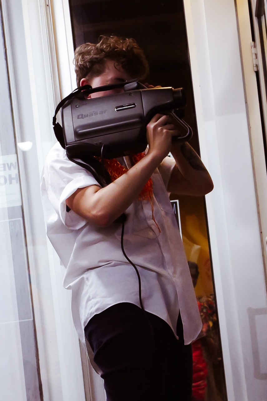 Charlie Best holding a large video camera that obscures their face